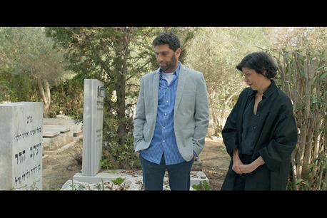 2 אנשים בבית עלמין מסתכלים על קבר